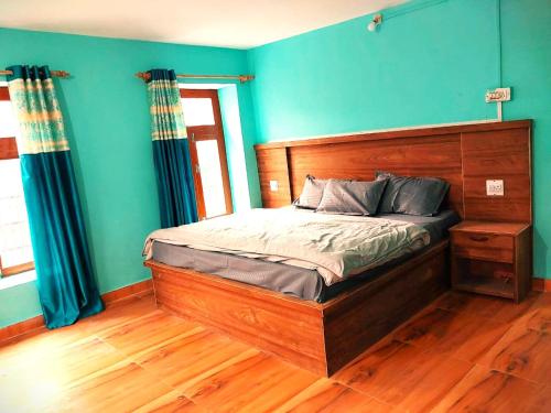 a bedroom with a wooden bed with blue walls at Yangling House in Sissu