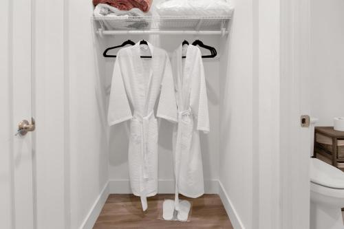 a bathroom with white clothes hanging on a rack at Nest Away 2 Queen near EWR-Penn- Free Parking in Newark