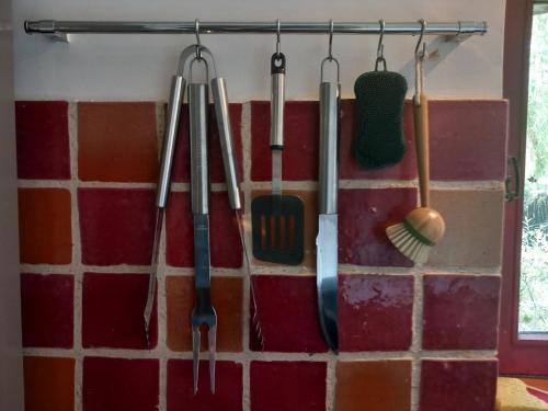 un mucchio di utensili da cucina appesi a un muro di Moulin en bord de rivière - 1 à 5 pers - logement atypique-linge-wifi a Chevillon-sur-Huillard
