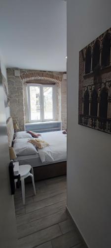 a bedroom with a large bed and a window at Studios Kadena Trogir - 18th century stone house in Trogir