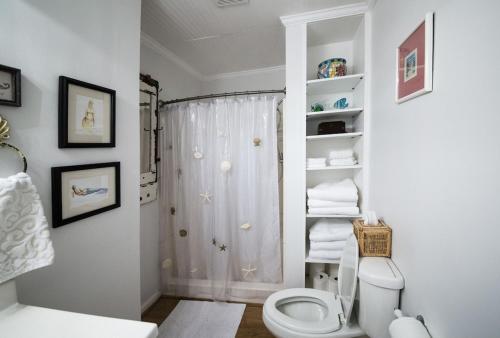 een witte badkamer met een toilet en een douche bij Mermaid Cottage Private Heated Pool ! in Demere Park