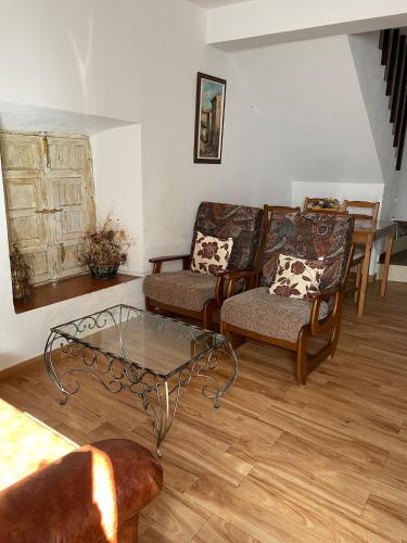 a living room with couches and a glass table at Alquiler rural Cútar, Casa Robles (en la Axarquía) in Cútar