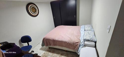 a small bedroom with a bed and a chair at Hostel AJBJ Turismo in Curitiba