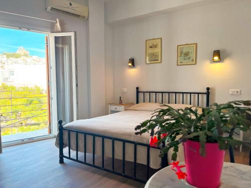 1 dormitorio con 1 cama y una maceta en Pefkakia Park, en Ermoupoli