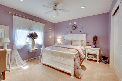 um quarto com uma cama branca e paredes roxas em Spacious Family Vacation Rental about 5 Mi to Beach! em Matawan