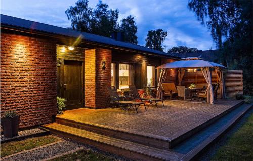 a wooden deck with a table and an umbrella at 3 Bedroom Stunning Home In Borgholm in Borgholm