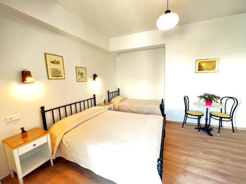 a bedroom with a bed and a table and chairs at Pefkakia Park in Ermoupoli