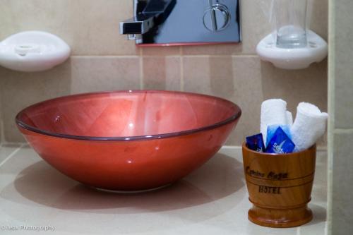 a red bowl on a counter in a bathroom at Hotel Ciudad Blanca in Copan Ruinas