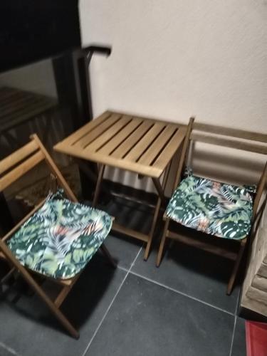 two chairs and a wooden table and a table and chairs at Apartman 007 in Kragujevac