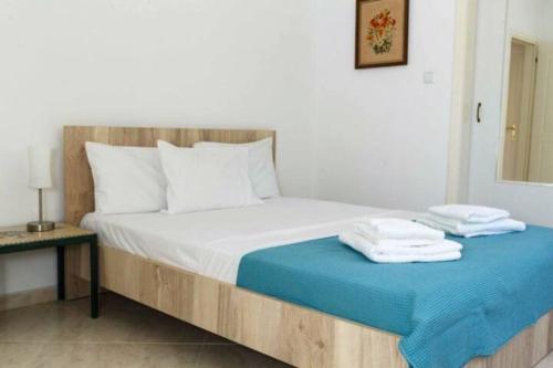 a bedroom with a bed with two towels on it at Villa Mary in Nea Kalikratia