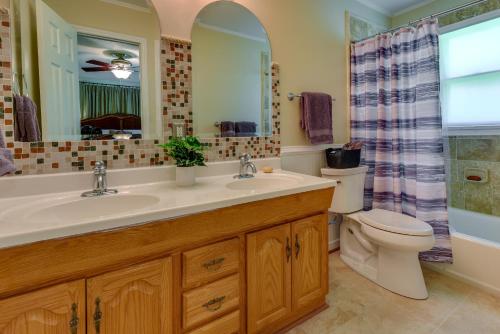 ein Badezimmer mit einem Waschbecken, einem WC und einem Spiegel in der Unterkunft Charlotte Vacation Rental with Private Hot Tub! in Matthews