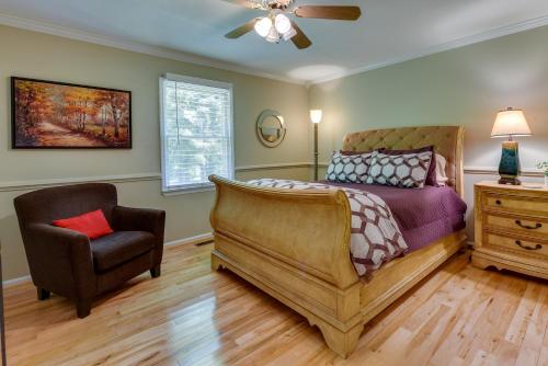 ein Schlafzimmer mit einem Bett und einem Stuhl in der Unterkunft Charlotte Vacation Rental with Private Hot Tub! in Matthews