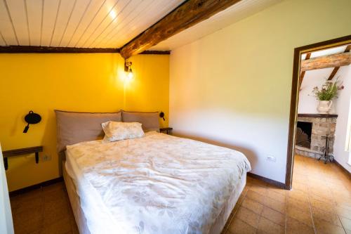1 dormitorio con cama y pared amarilla en Casa Soleggiata, en Mazzola