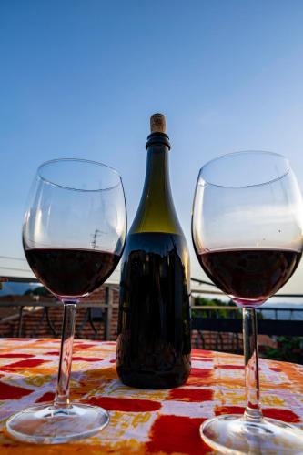 two glasses of wine on a table with a bottle of wine at Casa Soleggiata in Mazzola