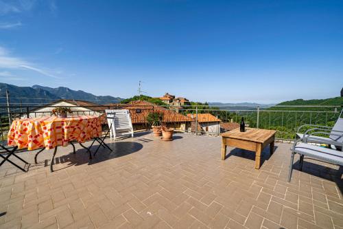 patio con mesa y sillas en el balcón en Casa Soleggiata, en Mazzola