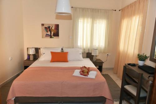 a bedroom with a large bed with an orange pillow at Eleni's Σπίτι μπροστά στη θάλασσα in Daratso