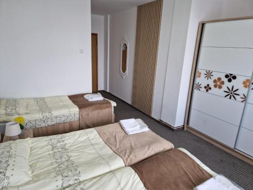 a hotel room with three beds and a balcony at ANTIK HOUSE in Cornu de Jos
