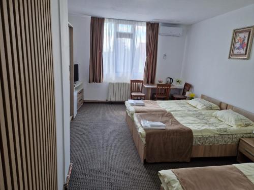 a hotel room with two beds and a table at ANTIK HOUSE in Cornu de Jos