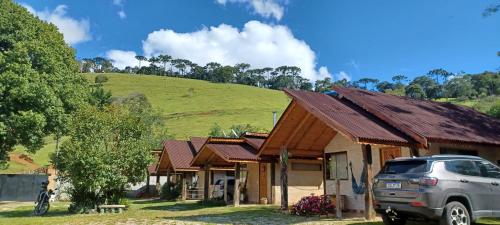a car parked in front of a house with a hill at Chalé na Montanha - Charme e Natureza in Santo Antônio do Pinhal