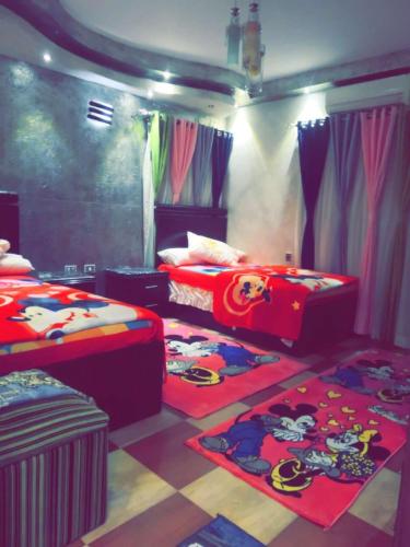 - une chambre avec 2 lits et des tapis au sol dans l'établissement شارع مدينه منوره, au Caire