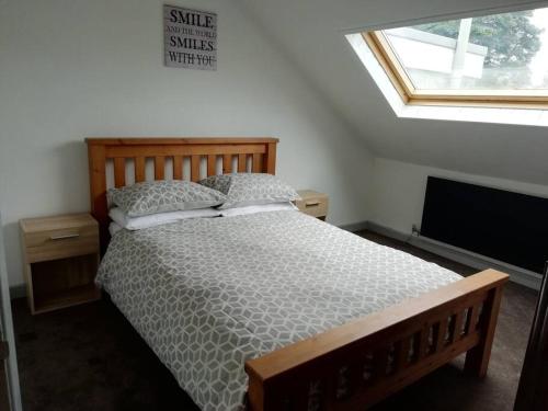 a bedroom with a bed and a window and a television at Haverfordwest terraced home in Pembrokeshire