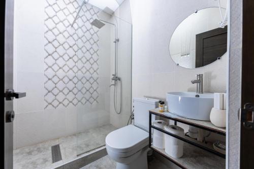 bagno con servizi igienici, lavandino e specchio di Bloom Hotel Yerevan a Yerevan