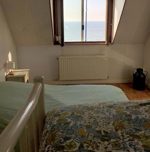 une chambre avec un lit avec vue sur l'océan dans l'établissement Le petit cottage le portel, à Le Portel