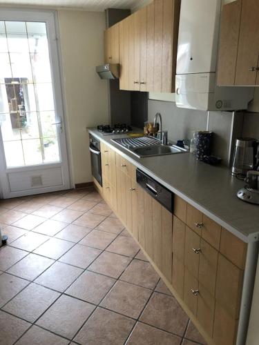 une cuisine avec un évier et une cuisinière four supérieur dans l'établissement Le petit cottage le portel, à Le Portel