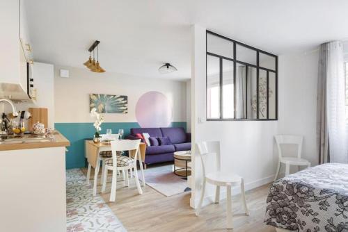 un salon avec un lit et une salle à manger dans l'établissement Le Pourpre, à Chelles