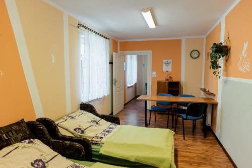 a room with two beds and a table with chairs at Pokoje Gościnne u Markusa in Polanica-Zdrój