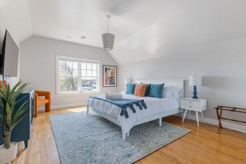 a white bedroom with a bed and a rug at Amazing family-friendly and group-friendly accommodation #TheBackDorch in Boston