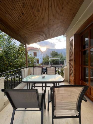a patio with a table and chairs on a balcony at Lemon Tree House in Leonidion