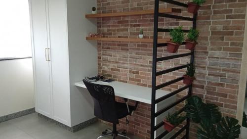 an office with a desk and a brick wall at Edifício Master in Cascavel
