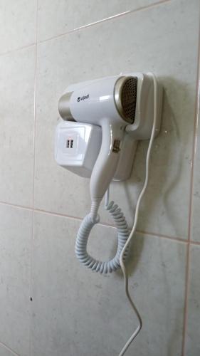 a hair dryer hanging on a wall in a bathroom at Edifício Master in Cascavel