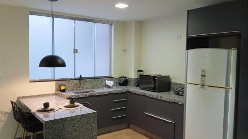 a kitchen with a refrigerator and a counter top at Edifício Master in Cascavel