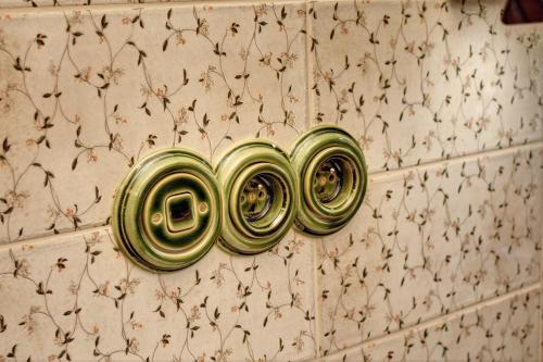 a wall with a bunch of gold plates on a wall at Roubenka pod Troskami in Ktová