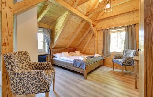a bedroom in a log cabin with a bed and two chairs at Roubenka pod Troskami in Ktová