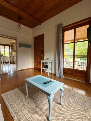 a living room with a table in the middle of a room at Lemon Tree House in Leonidion