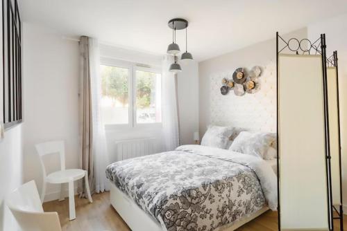 Habitación blanca con cama y espejo en Le Pourpre en Chelles