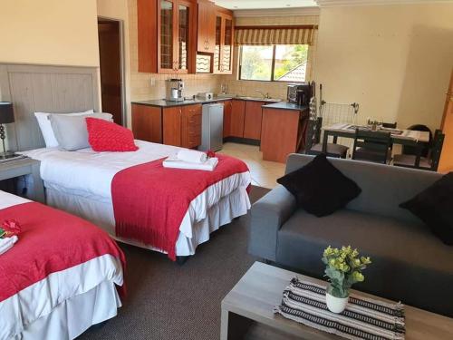 Habitación de hotel con 2 camas y sofá en Roosthaven Guesthouse en Centurion