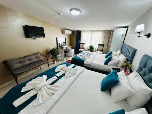 a hotel room with two beds and a couch at Galapera Hotel in Istanbul