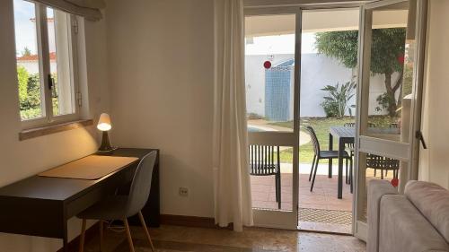 a room with a desk and a table with a view of a patio at Solar - Private Pool - 12 Guests - Albufeira in Albufeira