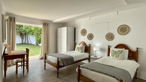 een slaapkamer met 2 bedden, een bureau en een raam bij Solar by Check-in Portugal in Albufeira