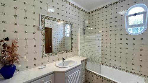 een badkamer met een wastafel en een spiegel bij Solar by Check-in Portugal in Albufeira
