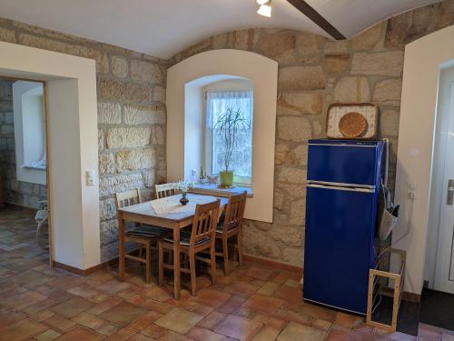 a kitchen with a table and a blue refrigerator at Ferienwohnung Hartmann in Hohnstein