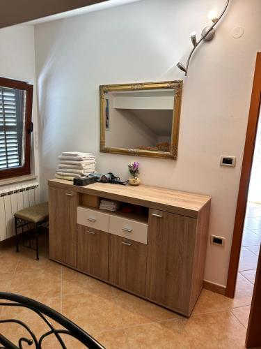 een badkamer met een wastafel en een spiegel aan de muur bij Apartments Primani in Sečovlje