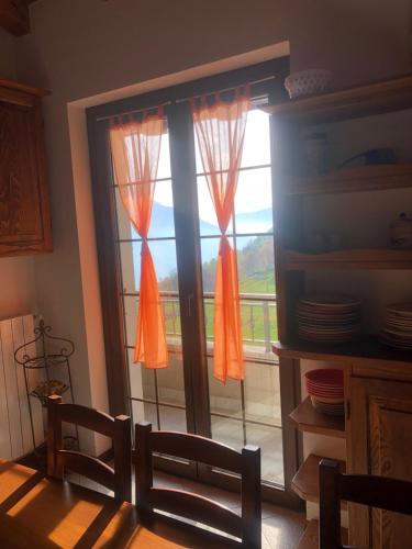 a dining room with a sliding glass door with a balcony at Baita Poira in Mello