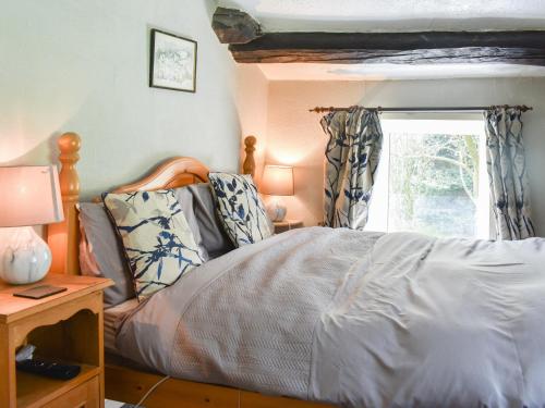 a bedroom with a bed and a window at Red Squirrel Haven in Hawes