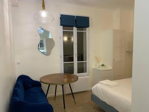 a small room with a table and a bed at Cosy studio a 20 min del Arco del Triunfo en RER in Maisons-Laffitte