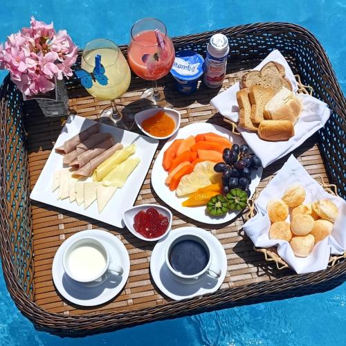 a table with a tray of different types of food at HOTEL KICHARME PONTAL in Fortim